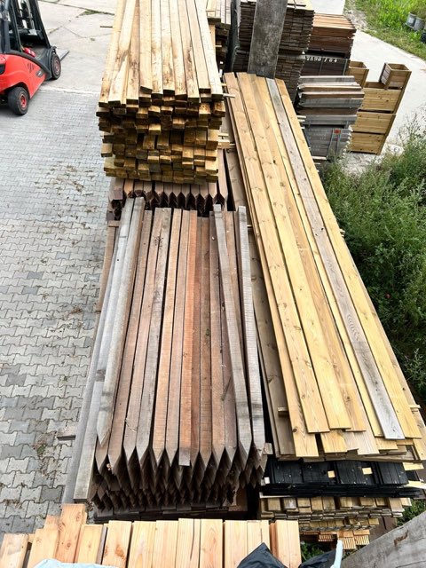 Palen en geschaafd hout, klaar voor de zaag